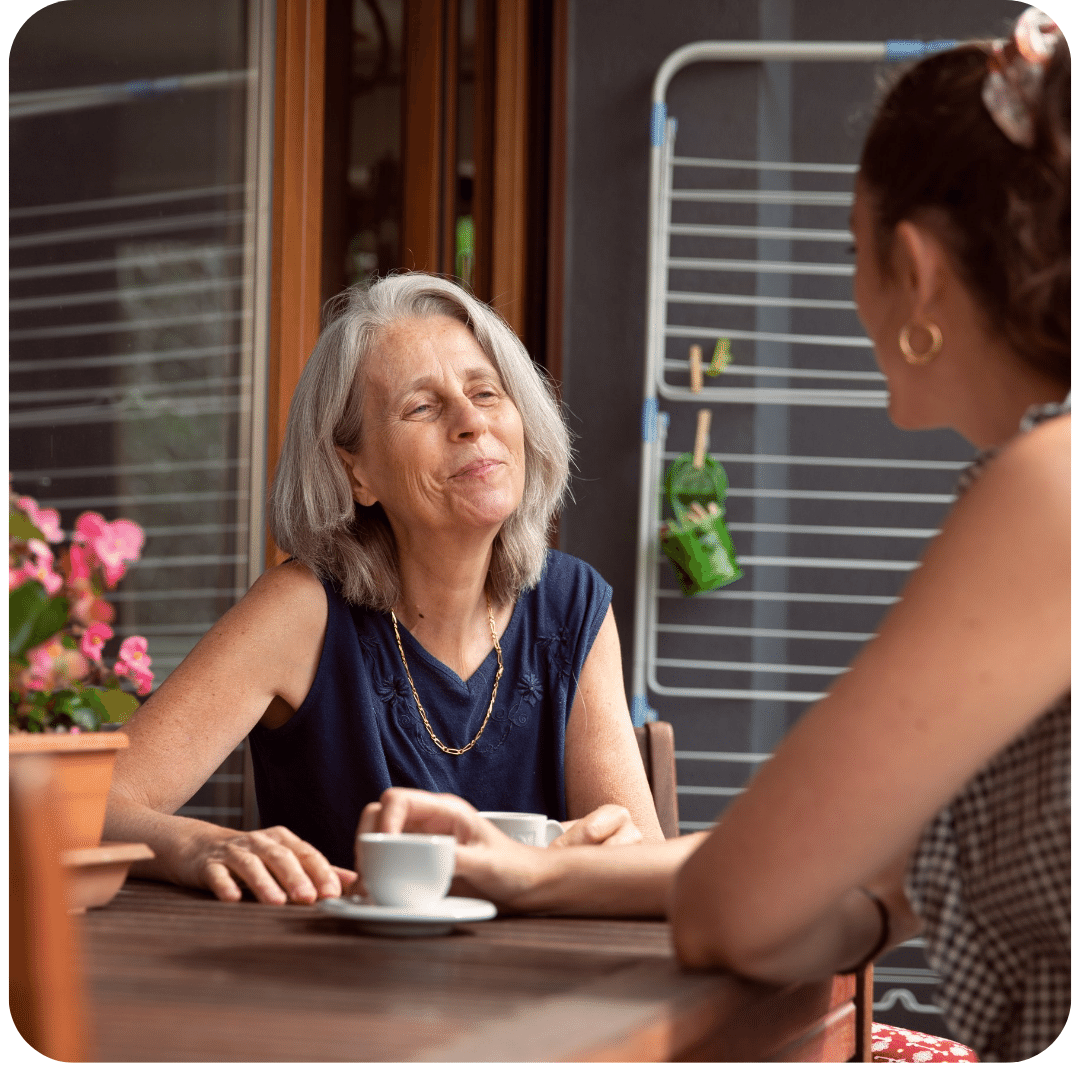 Une retraité et une étudiante discutent autour d'un café
