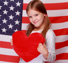Fille tenant un coeur sur fond drapeau USA